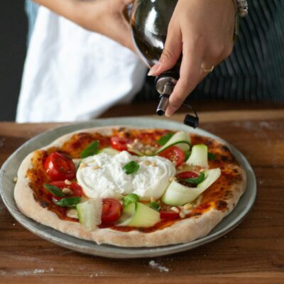 a person is putting cheese on a pizza